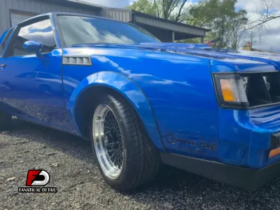 A professional using a dual-action polisher to perform a paint correction.